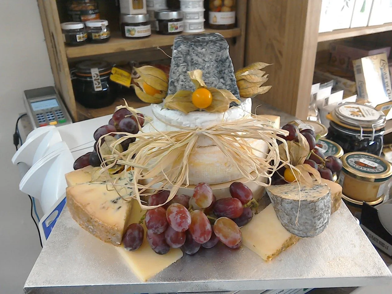 A tiered celebration cheese cake, whole cheeses dressed with grapes and physalis.